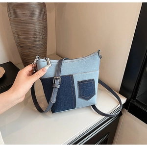 Detailansicht der zweifarbigen Denim-Umhängetasche mit Ziernähten und Silberbeschlägen