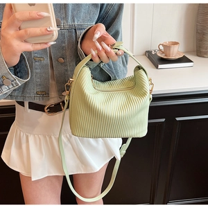 Détail du sac à main plissé vert pistache avec boucles dorées et bandoulière amovible