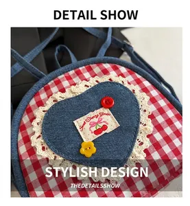 Detail of red plaid crossbody bag with denim heart patch, lace trim and cherry embroidery