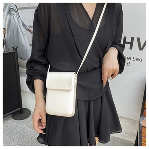 Mini bolso bandolera blanco vertical en modelo dentro de un entorno urbano minimalista