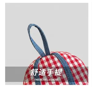 Detailed close-up showing the red and white quilted fabric with blue denim handle stitching