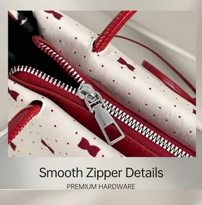 Close-up of a smooth silver zipper on a red polka dot and bow pattern shoulder bag