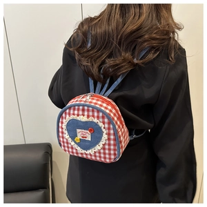 Detail of red gingham mini backpack with denim heart patch and lace trim details