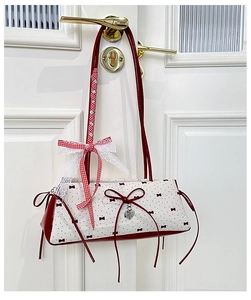 Detail of red and white polka dot bag with bow ribbons and lace hanging on a door