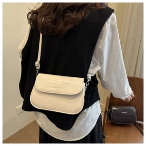 Detailweergave van de stijlvolle gebroken witte minimalistische crossbodytas bij een model