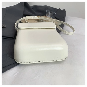Detail view of cream white minimalist crossbody phone bag with adjustable leather strap