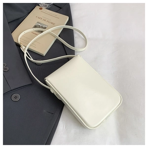 Minimalist white crossbody square bag styled with a blazer and vintage French book