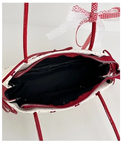 Draufsicht der weißen gepunkteten Tasche mit roter Schleife und Metallreißverschluss
