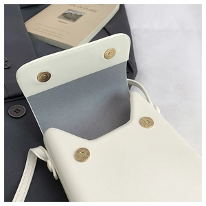 Detailed view of the double magnetic closure and cat-ear flap on white crossbody bag