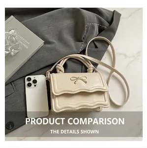 Chic mini cream crossbody bag with bow detail shown next to a smartphone for size reference