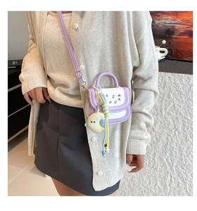 Detail of mini square crossbody bag with cherry print and plush moon pendant