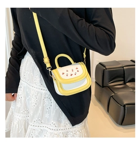 Detailed side view of yellow and white mini crossbody bag with cherry print on model