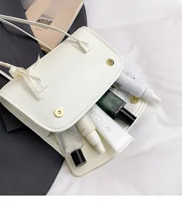Vue rapprochée d'un sac baguette blanc style ballet avec rabat magnétique et intérieur spacieux