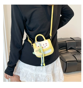 Mini crossbody bag with cherry print, moon charm, and woven rope detail shown on model