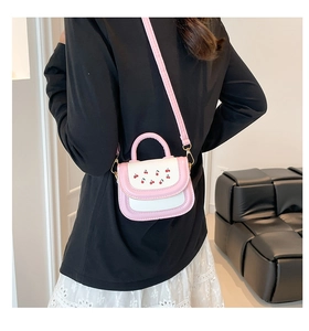 Rear view of a girl wearing a cherry-patterned pink and white mini crossbody handbag