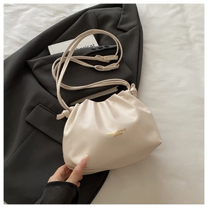 Detail of off-white pleated bucket bag featuring golden logo on soft synthetic leather