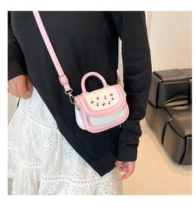 Detail view of mini pink and beige leather handbag with cherry embroidery and gold hardware