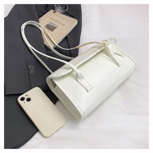 Chic pearl white shoulder bag with decorative bow knot detail on minimalist textured fabric