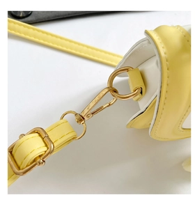 Close-up of yellow and white leather handbag with polished light gold metal hardware