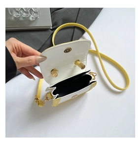 Detail of yellow and white crossbody bag interior with gold metal twist lock and magnetic snap