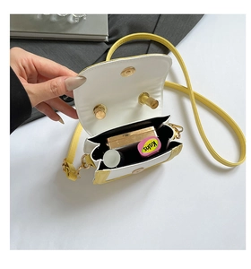 Detailed interior of a yellow mini handbag showing magnetic closure and storage capacity