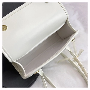 Top view of open white faux leather bag showing internal storage and golden magnetic buckle