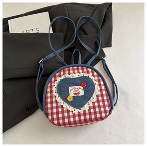 Detail of red plaid backpack with heart denim patch, lace trim and sweet cherry embroidery