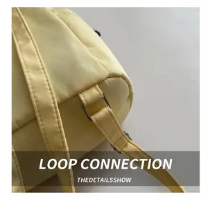 Detail of the silver metal ring connection on a light yellow fabric casual backpack