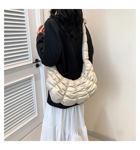 Detailed back view of a beige ruched crescent bag with soft quilted clouds texture
