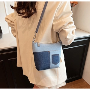 Detail der blauen Denim-Patchwork-Umhängetasche mit Silberhaken und dekorativer Tasche
