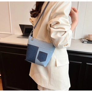 Details der Denim-Patchwork-Umhängetasche mit Ziertasche und silbernem Reißverschluss