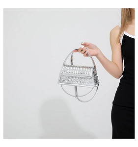 Close-up of silver crocodile embossed handbag with sleek metallic finish and handle