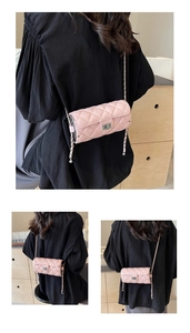 Détails du sac matelassé rose avec fermoir rotatif argenté et bandoulière en chaîne
