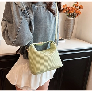 Détail du sac à main plissé vert menthe avec finitions dorées et fine bandoulière