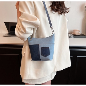 Detailansicht der blauen Denim-Patchwork-Umhängetasche kombiniert mit weißem Damenblazer