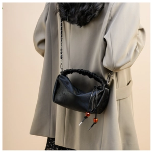 Détail du sac noir à poignée plissée avec perles orange et bandoulière chaîne argent