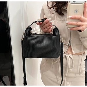 Vue détaillée du sac à main plissé noir avec finitions dorées et bandoulière réglable
