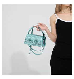 Detail of metallic blue faux crocodile leather handbag with elegant handle and shoulder strap