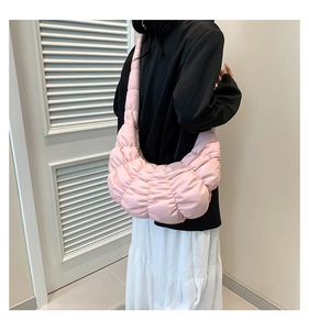 Close-up of pink quilted bubble cloud bag showing shoulder texture and puffy crescent shape