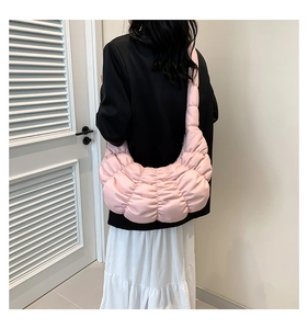 Close-up of pink ruched cloud bag showing quilted texture and wide shoulder strap