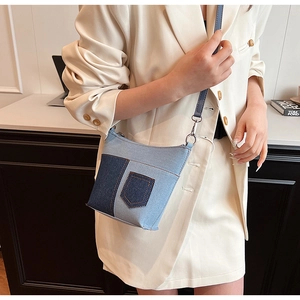 Nahaufnahme der Denim-Patchwork-Tasche mit Silberringen und stilvollen Nähten