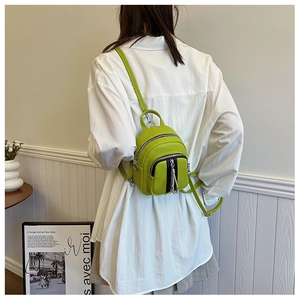 Detailansicht des fruchtgrünen Mini-Rucksacks aus Kieselleder mit silbernen Zippern