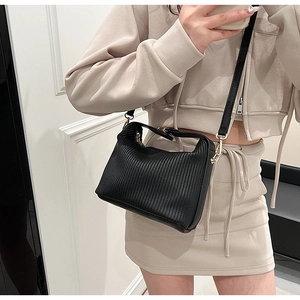 Selfie miroir présentant un sac bandoulière noir plissé avec finitions dorées