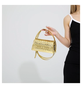 Detailed view of golden quilted handbag with glossy finish and textured bubble design