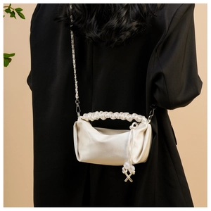 Détail du sac nuage blanc plissé avec cordon perlé et bandoulière sur manteau noir