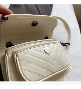 Close-up of beige crossbody bag with V-quilt stitching and silver metallic magnetic clasp