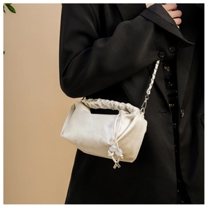 Détail du sac à main plissé crème avec texture marbre et bandoulière chaîne