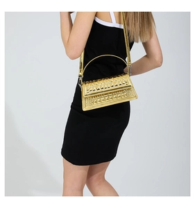 Detailed macro view of the glossy gold textured surface and embossed pattern of the handbag