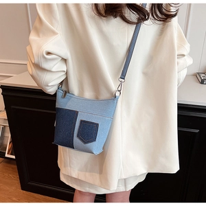 Detail der blauen Denim-Patchwork-Beuteltasche mit Ziernähten und schmalem Gurt