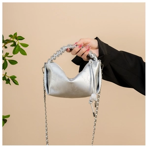 Détail de la poignée froncée et texture métallique craquelée sur le sac nuage chic